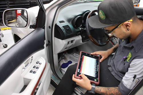 A mechanic checking a car's diagnostics at A+ Japanese Auto Repair in San Carlos, CA